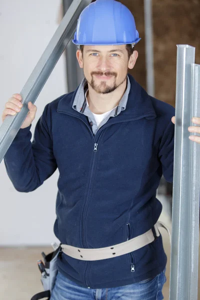 Portrait of builder holding aluminium frames — Stock Photo, Image