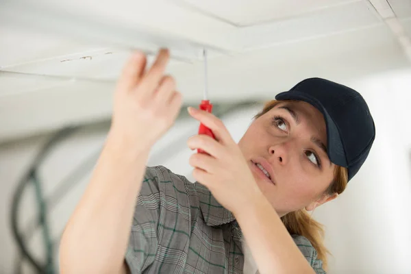Female worker change of a light bulb — Stock Photo, Image
