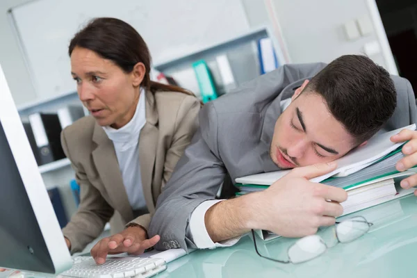 Gerente junto a una trabajadora de oficina durmiendo — Foto de Stock