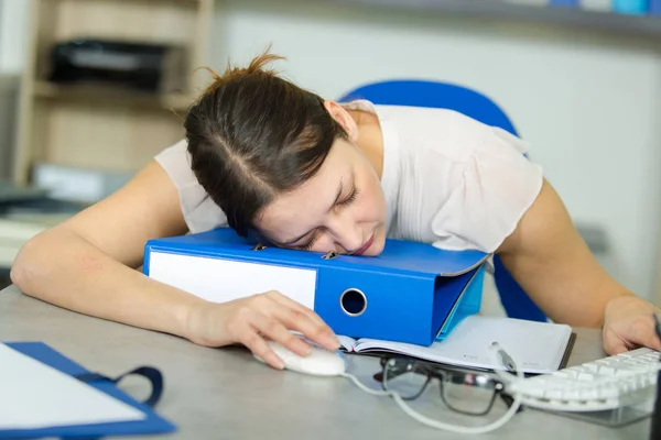 Женщина, спящая за письменным столом, все еще на мышке — стоковое фото