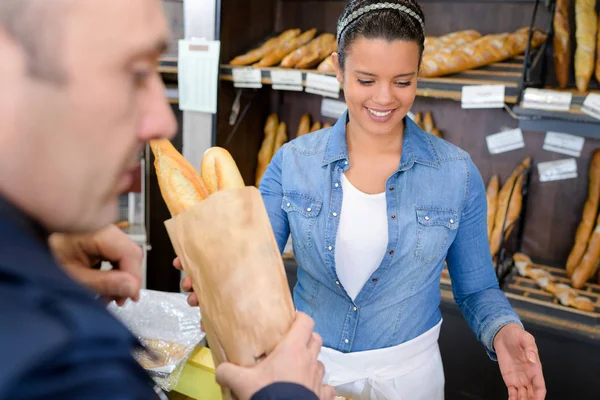 Baguetes sendo vendidos em uma padaria — Fotografia de Stock