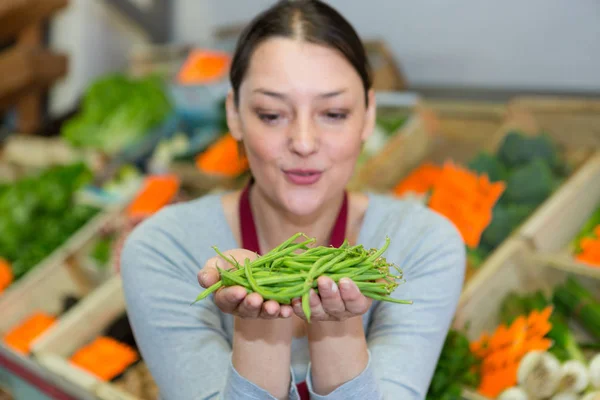 Frau wählt grüne Bohnen im Hofladen — Stockfoto