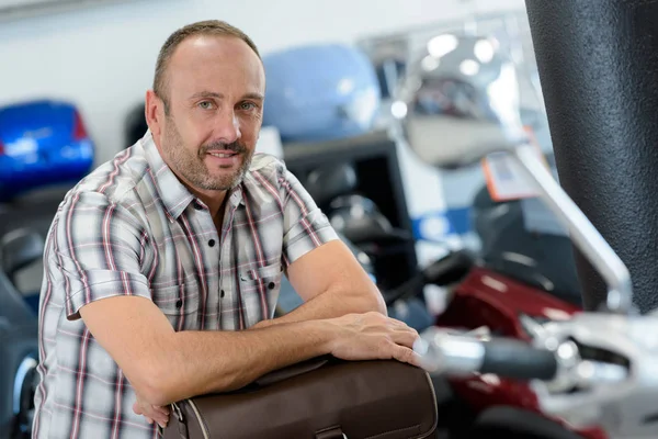 Uomo in posa nel negozio di moto — Foto Stock