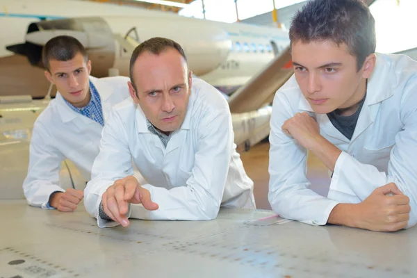 Team di studenti di aviazione che studia piani — Foto Stock