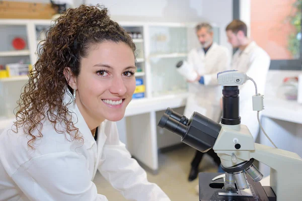 Retrato de mujer joven al microscopio —  Fotos de Stock