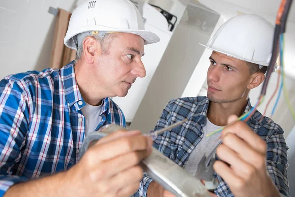 Two electricians wiring at construction site — Stock Photo, Image
