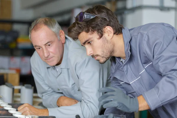 Jonge machinist en zijn trainer die een taak uitvoeren — Stockfoto