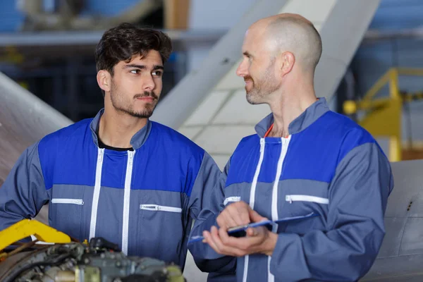 Portret van moderne vliegtuigingenieurs in hangar — Stockfoto