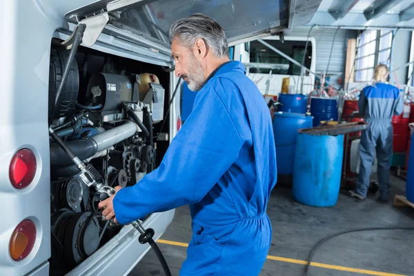 Mecânico do carro na garagem verificando um carro — Fotografia de Stock