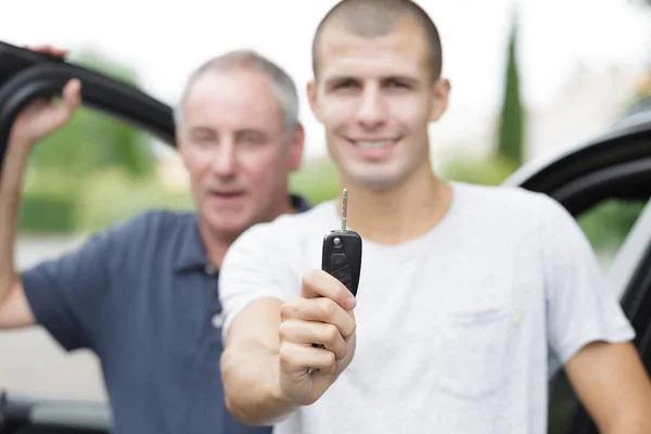 Glad ung man håller bilnycklar — Stockfoto