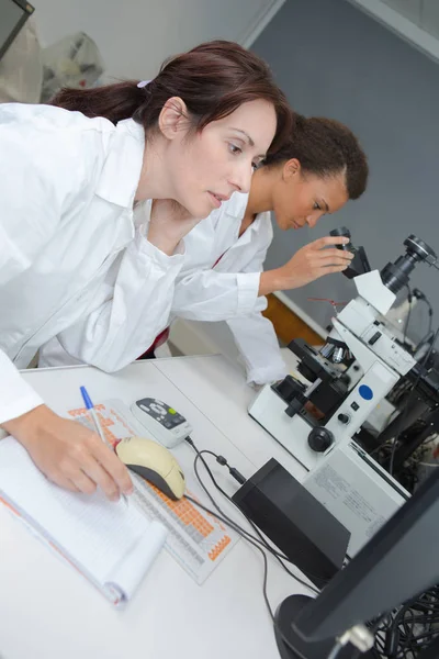 Usuarios de un microscopio en laboratorio — Foto de Stock