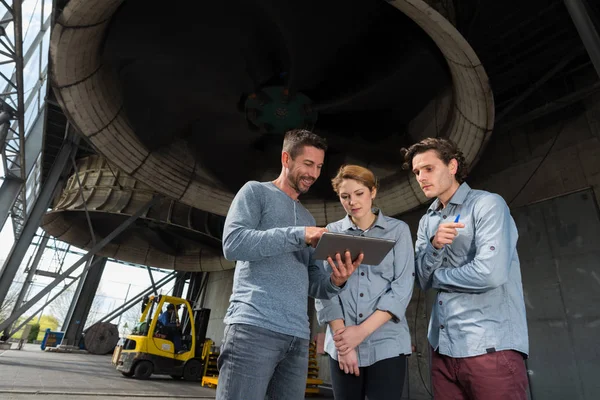 Arbetare bredvid ventilator i fabrik med moln och himmel — Stockfoto