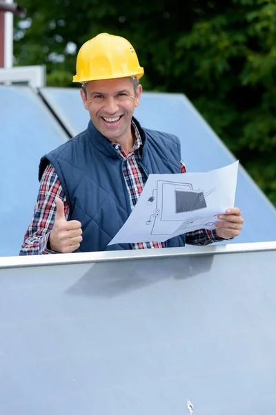 Worker stood amongst solar panels showing thumbs up — Stock Photo, Image