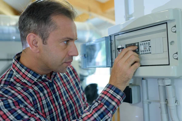 Een man die een machine herstelt — Stockfoto