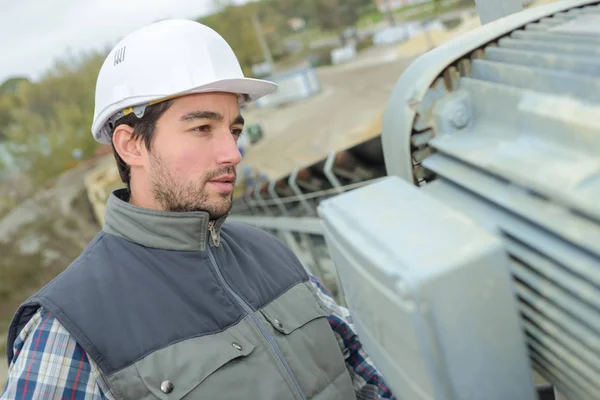 Arbeiter inspiziert Motor auf Förderband — Stockfoto