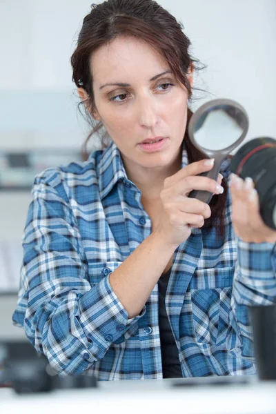 Female photographer using a magnifying glass — Stock Photo, Image