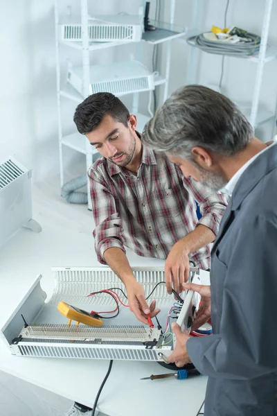 En hantverkare fixar kunder radiator — Stockfoto