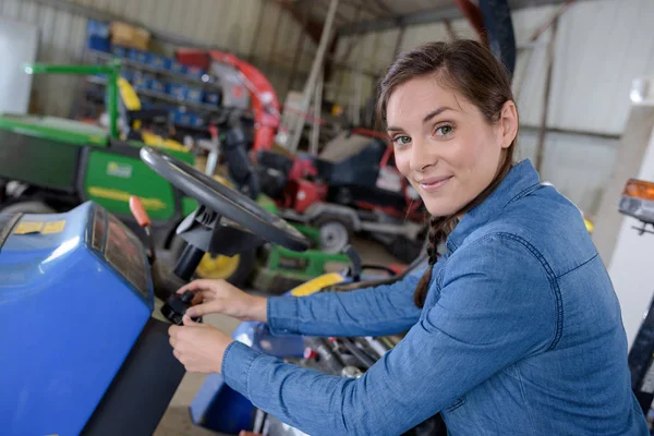 En kvinna är på en traktor — Stockfoto