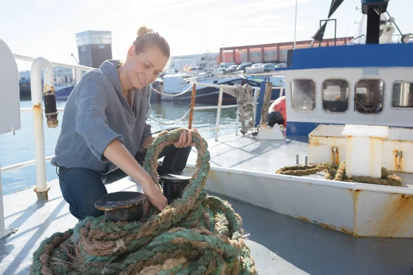 Mujer tirando de la cuerda en la cubierta de un barco —  Fotos de Stock