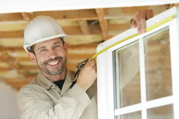 Ein glücklicher Mann, der Fenster misst — Stockfoto