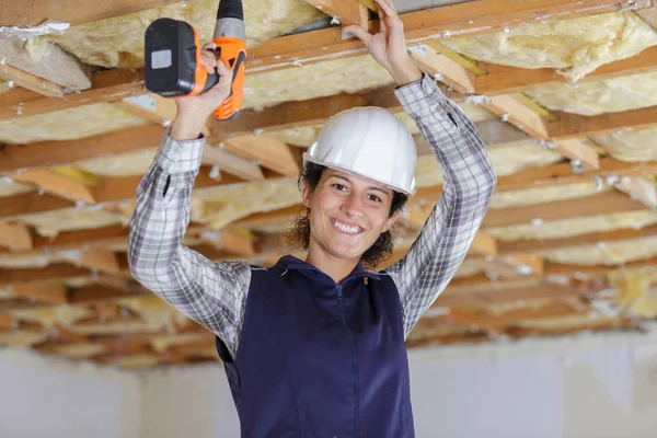 A female worker is drilling ceiling — 스톡 사진