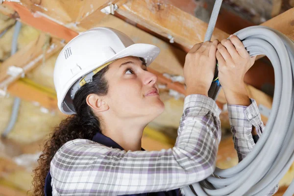 Portret van vrouwelijke bouwer in helm met kabel — Stockfoto