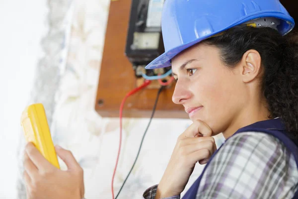 Unga kvinnliga elektriker alalyserande resultat på hennes multimeter — Stockfoto