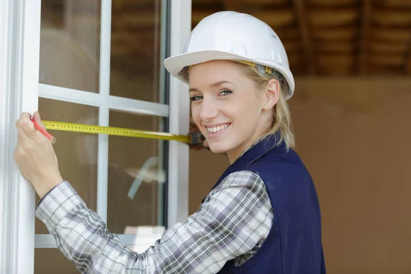 Feliz trabajadora mide una ventana —  Fotos de Stock