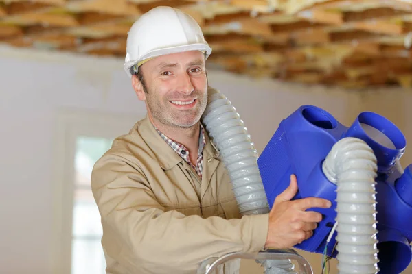 Man met flexibele slang in dakruimte — Stockfoto