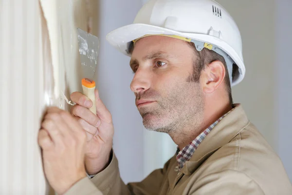 Professionele mannelijke strippen behang met een schraper — Stockfoto