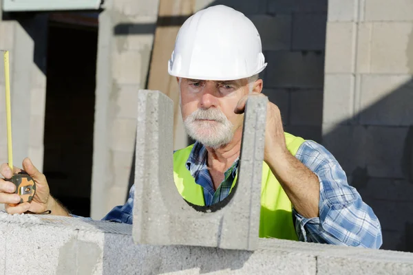 Homem sênior trabalhando com paredes de concreto — Fotografia de Stock