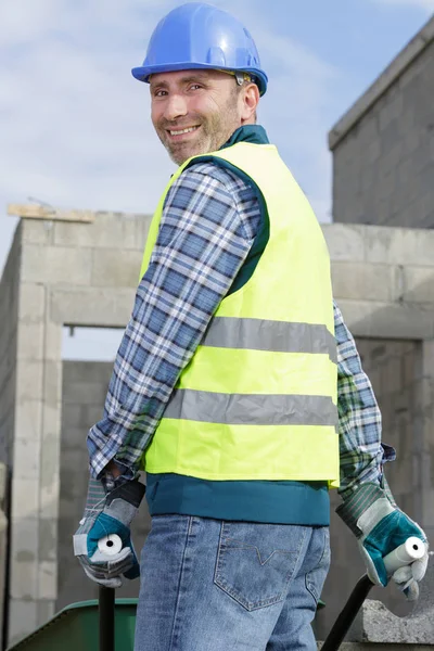 Bauarbeiter trägt Bauklötze auf einer Schubkarre — Stockfoto