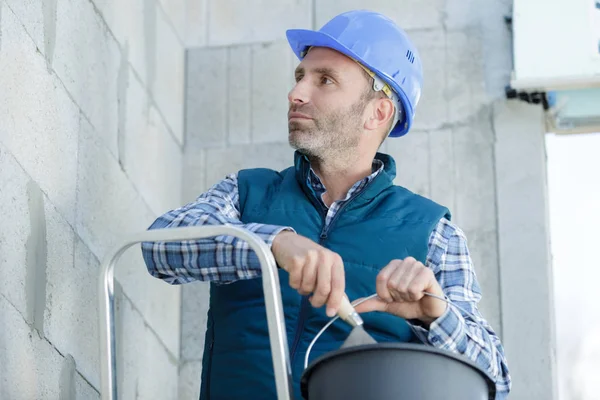 Porträt eines Bauunternehmers, der Zementwände überprüft — Stockfoto