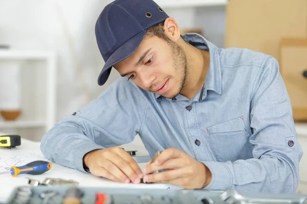 A young serviceman assembling parts — Stock Photo, Image