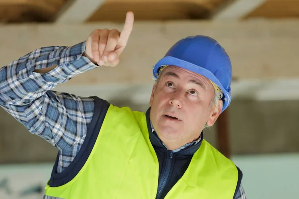 En byggare som pekar på något — Stockfoto