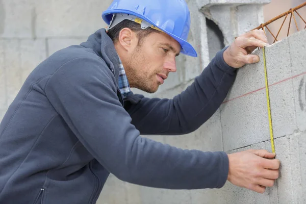 Portrait du travailleur de la construction utilisant le niveau du mur — Photo