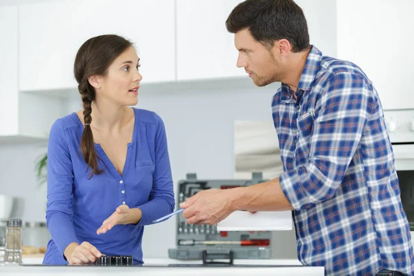 Kobieta z mężem próbuje naprawić kuchnię — Zdjęcie stockowe