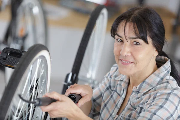 Seniorin repariert Fahrrad — Stockfoto