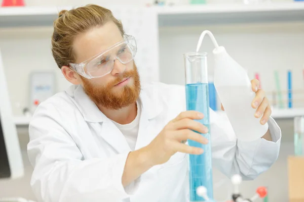 Trabalhador de laboratório bonito misturando líquidos — Fotografia de Stock