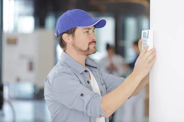 Os homens regulam a temperatura no painel de controle — Fotografia de Stock