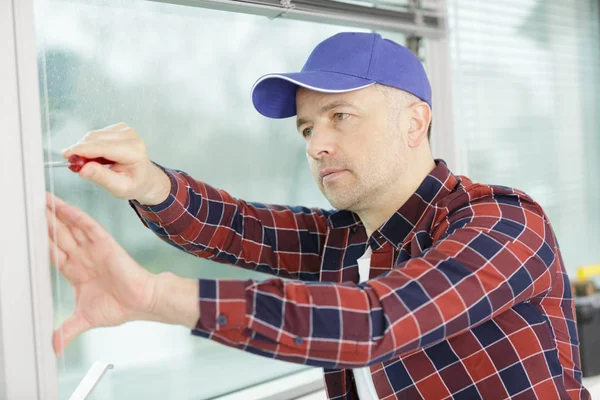 Maschio lavoratore stringe la finestra tappo vite — Foto Stock