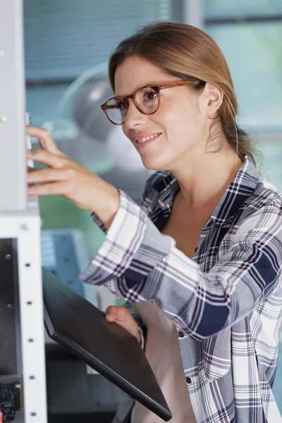 Kvinna reacher för en mapp från kontorshyllan — Stockfoto