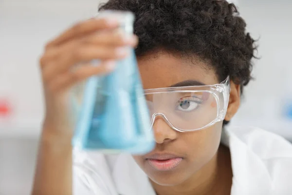 Woman in the lab holding a flask — Stock Photo, Image