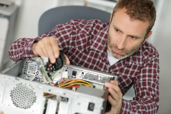 Erkek mühendis ofiste bozuk bilgisayarı tamir ediyor. — Stok fotoğraf