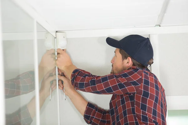 Technicien installant une alarme au plafond à l'intérieur — Photo