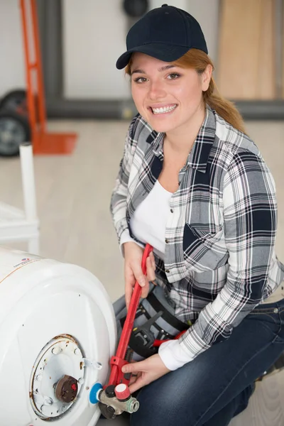 Felice idraulico femminile che lavora sulla caldaia di riscaldamento centrale — Foto Stock