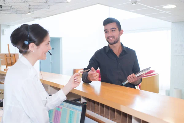 Recepcionista médica dando o cartão mans de volta — Fotografia de Stock