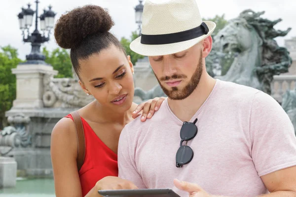 Retrato de pareja feliz usando tableta digital en la ciudad — Foto de Stock