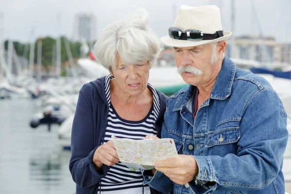Старша пара дивиться на туристичну карту — стокове фото