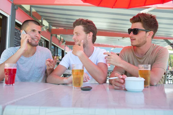 De vrienden die buiten bier drinken — Stockfoto